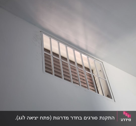 סורגי מתכת על חלון עם תריסים